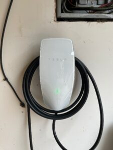 Tesla electric car charging at a home charging station